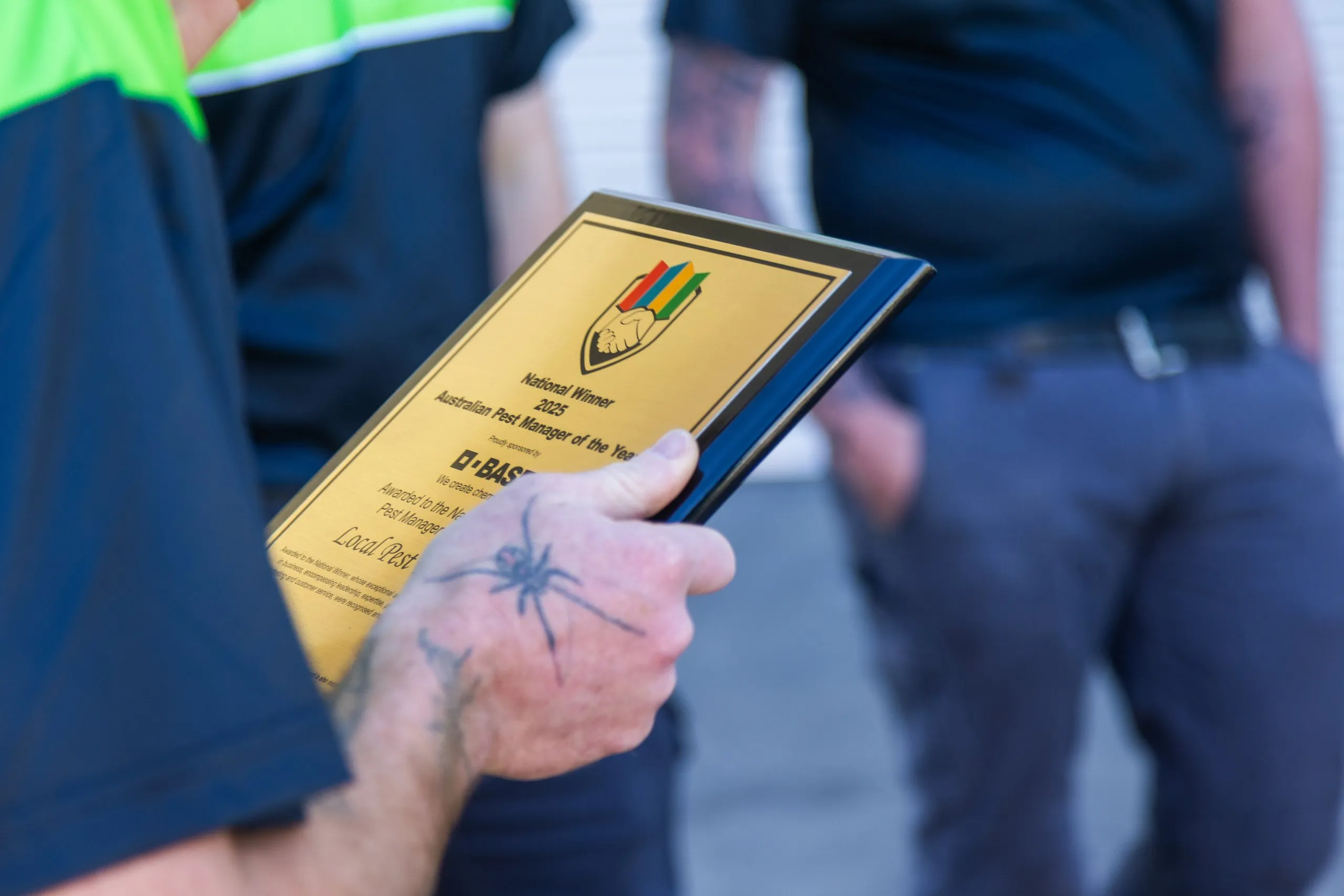 A Local Pest Experts technician holding the 2025 Australian Pest Manager of the Year plaque